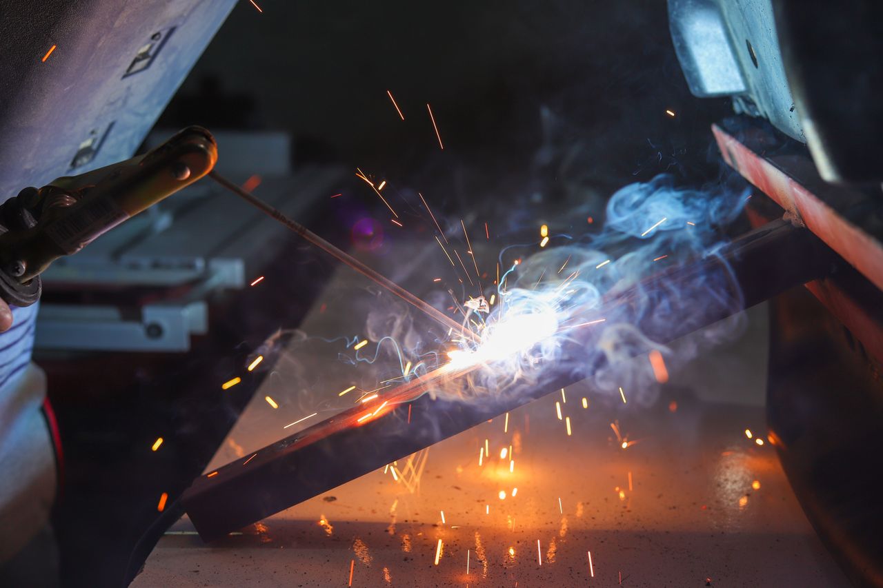 The Art of Drawing Readers In: Your attractive post title goes here Close-up of a welder at work with sparks and smoke in an industrial setting.