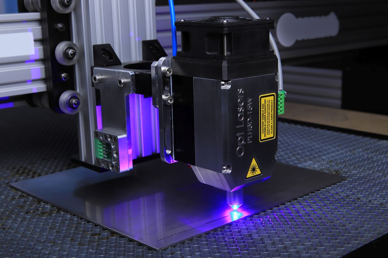 About Close-up of a laser engraving machine operating on a metal surface with blue laser light.